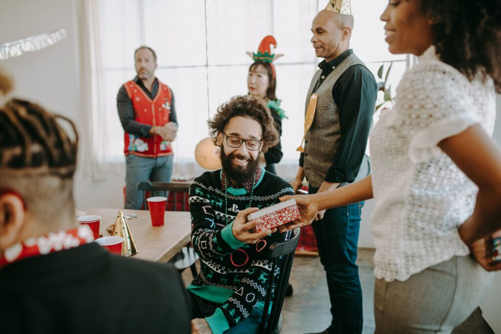 trabajadores con atuendo navideño dando regalos